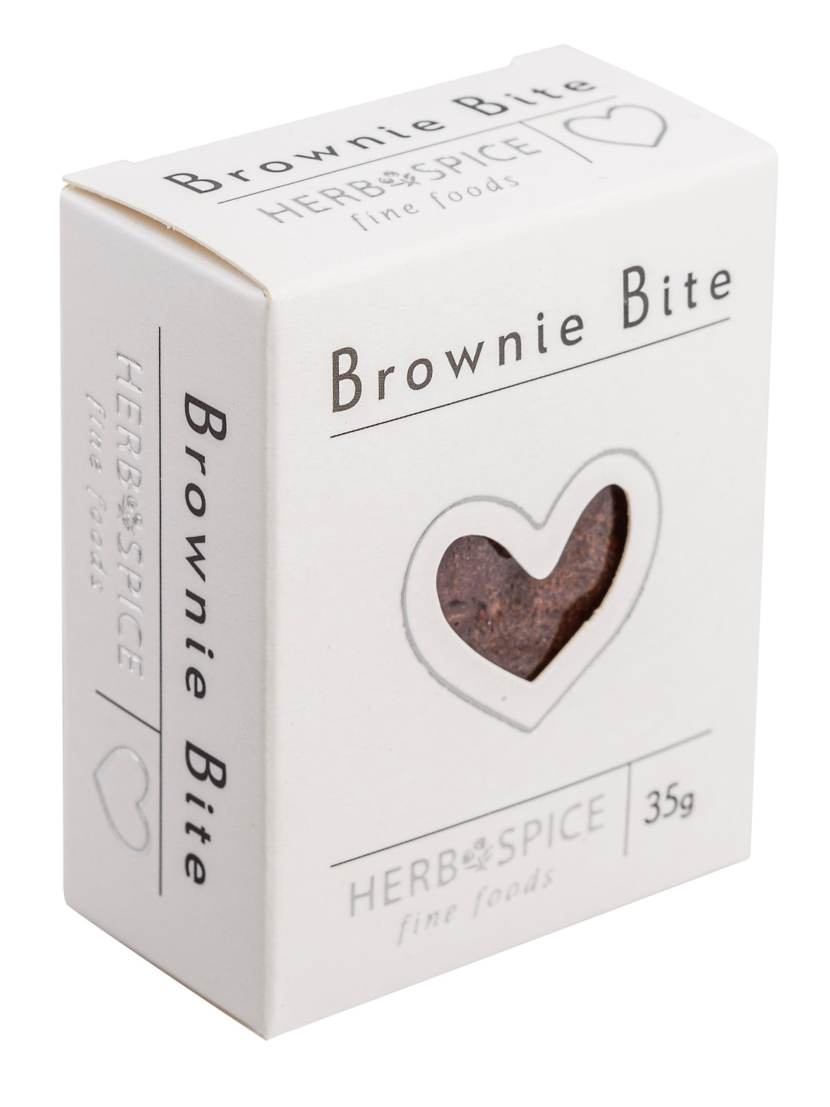 A white cardboard box of Herb & Spice Brownie Bite, featuring a heart-shaped window on the front that reveals a brownie inside. The packaging is clean and minimalist, set against a plain white background.