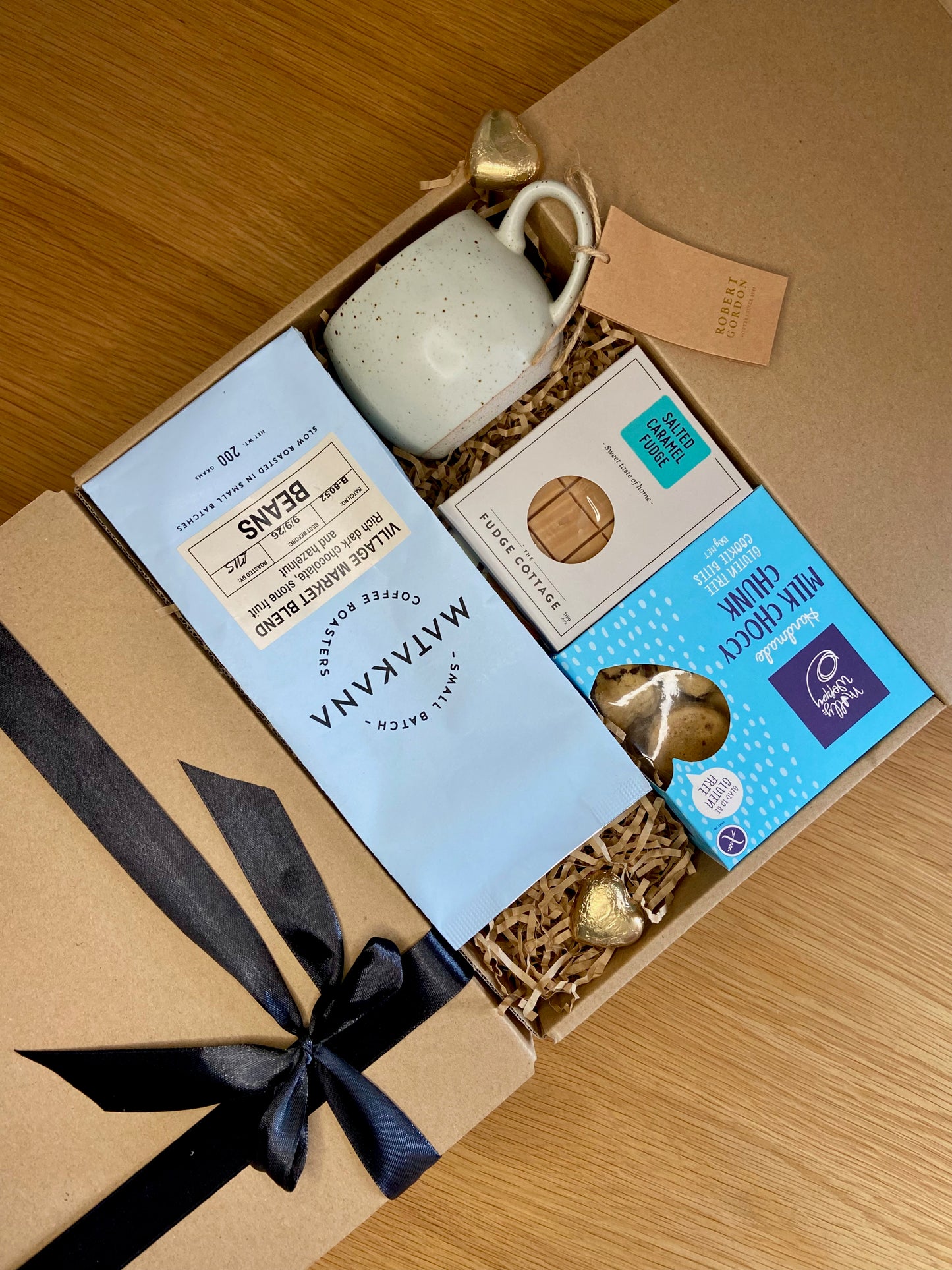 Gift box with a coffee, mug, cookies, and fudge. Beautiful ribbon and gift card option.